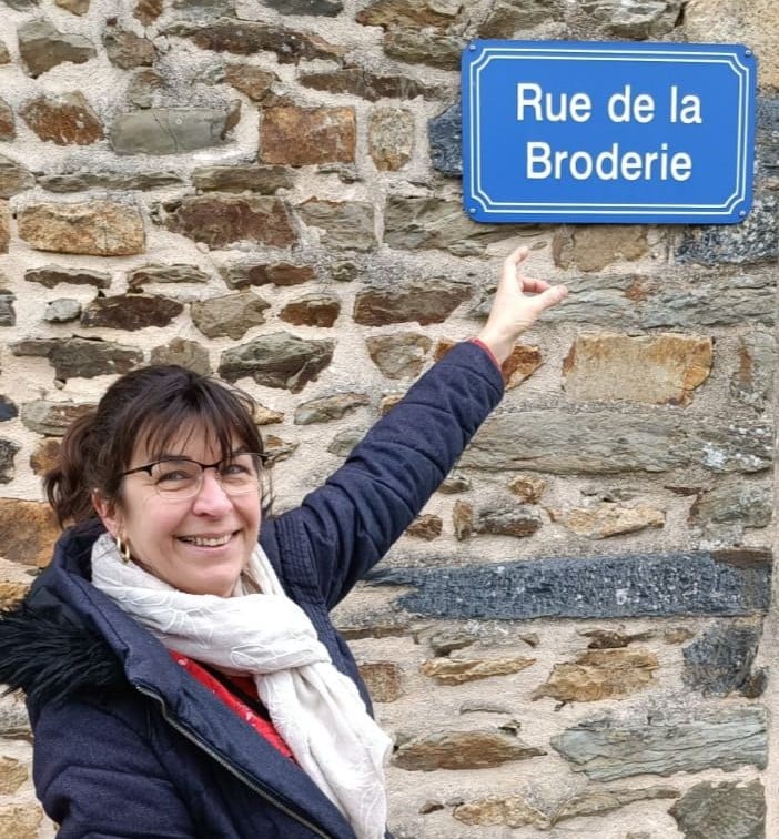 Mamitine devant un panneau de rue : Rue de la Broderie